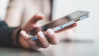 スマートフォンを操作する手元