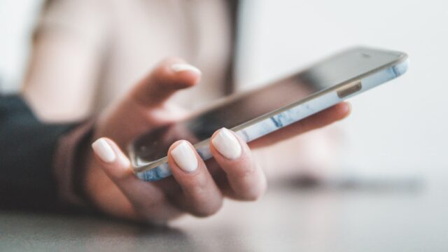 スマートフォンを操作する手元