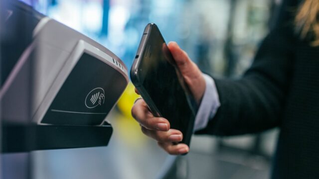 スマートフォンを決済端末にかざしてタッチ決済をする様子。非接触決済のイメージ写真