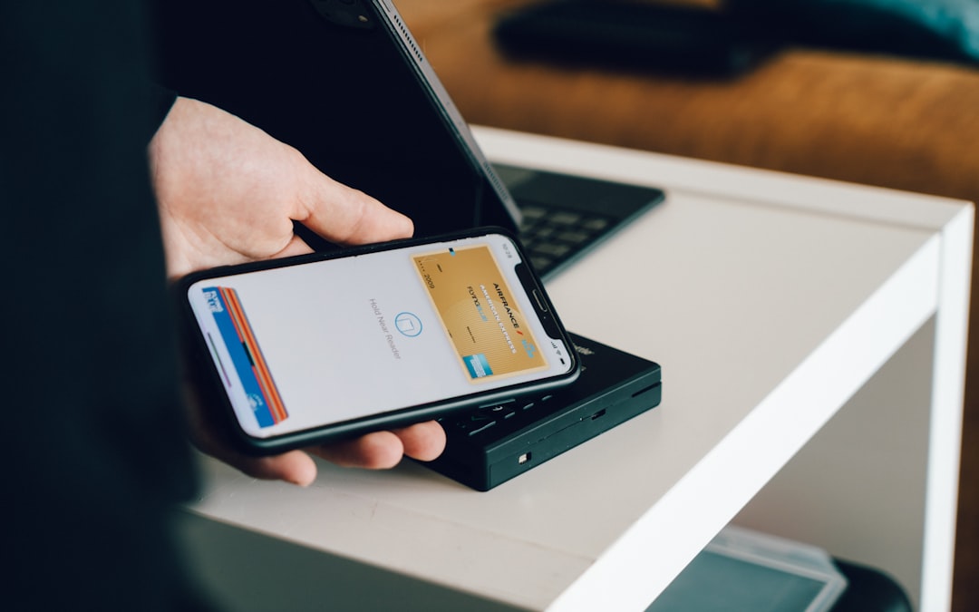 スマートフォンでモバイル決済のカード画面を表示し、カードリーダーにかざしている写真。決済方法の選択をイメージ。